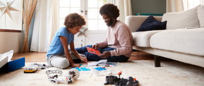 Man and Boy Assembling Toy in Living Room